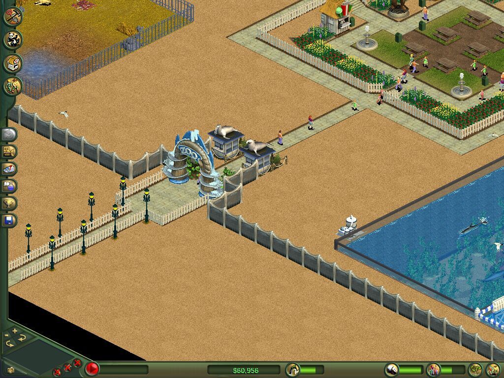 A marine tank with a swimming animal beside a fenced path.
